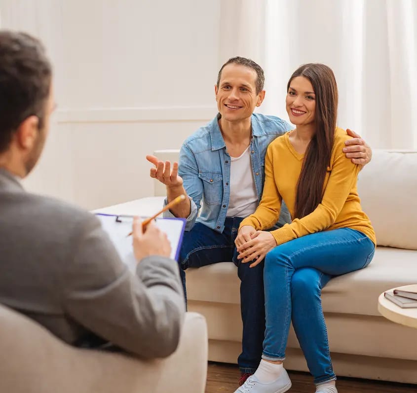 A couple talking with a therapist in a bright office