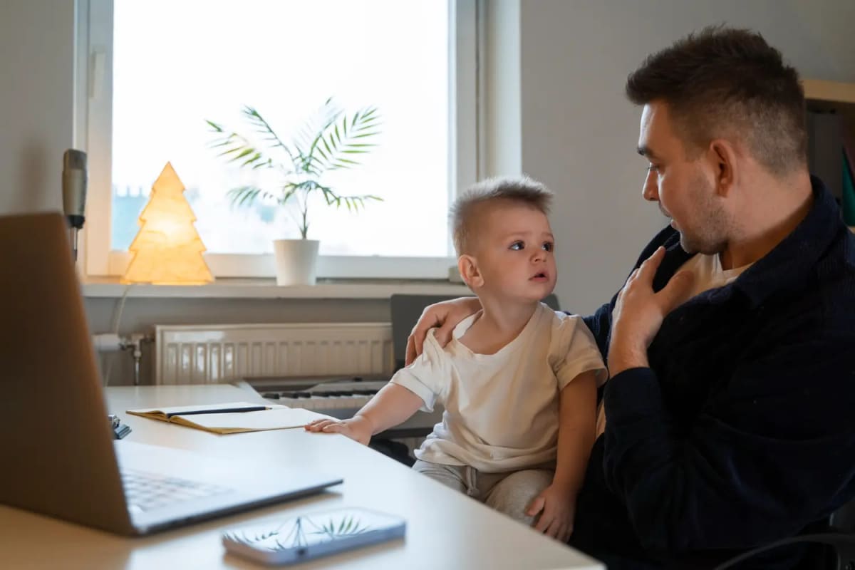 A father sitting with his young child at home