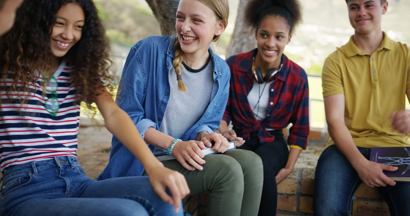 A group of teenagers sitting together outside