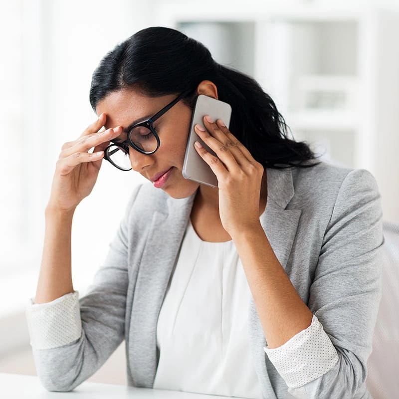 A professional woman on the phone, overwhelmed at work